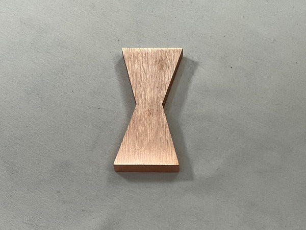 A single 1/4" Large Copper Metal Bowtie Inlay made by Slab Stitcher