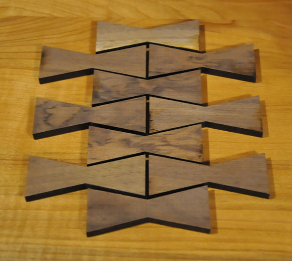 A group of medium wooden Walnut bowtie inlays